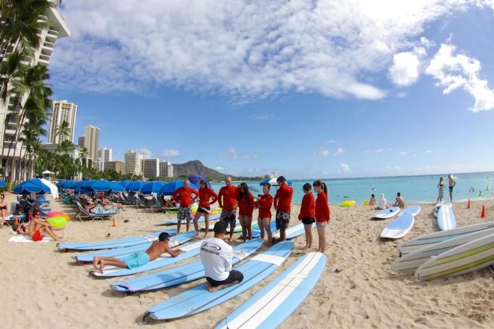 a group of people standing on top of a sandy beach