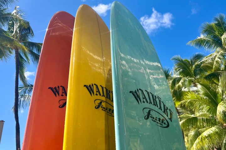 a group of people standing on top of a surfboard